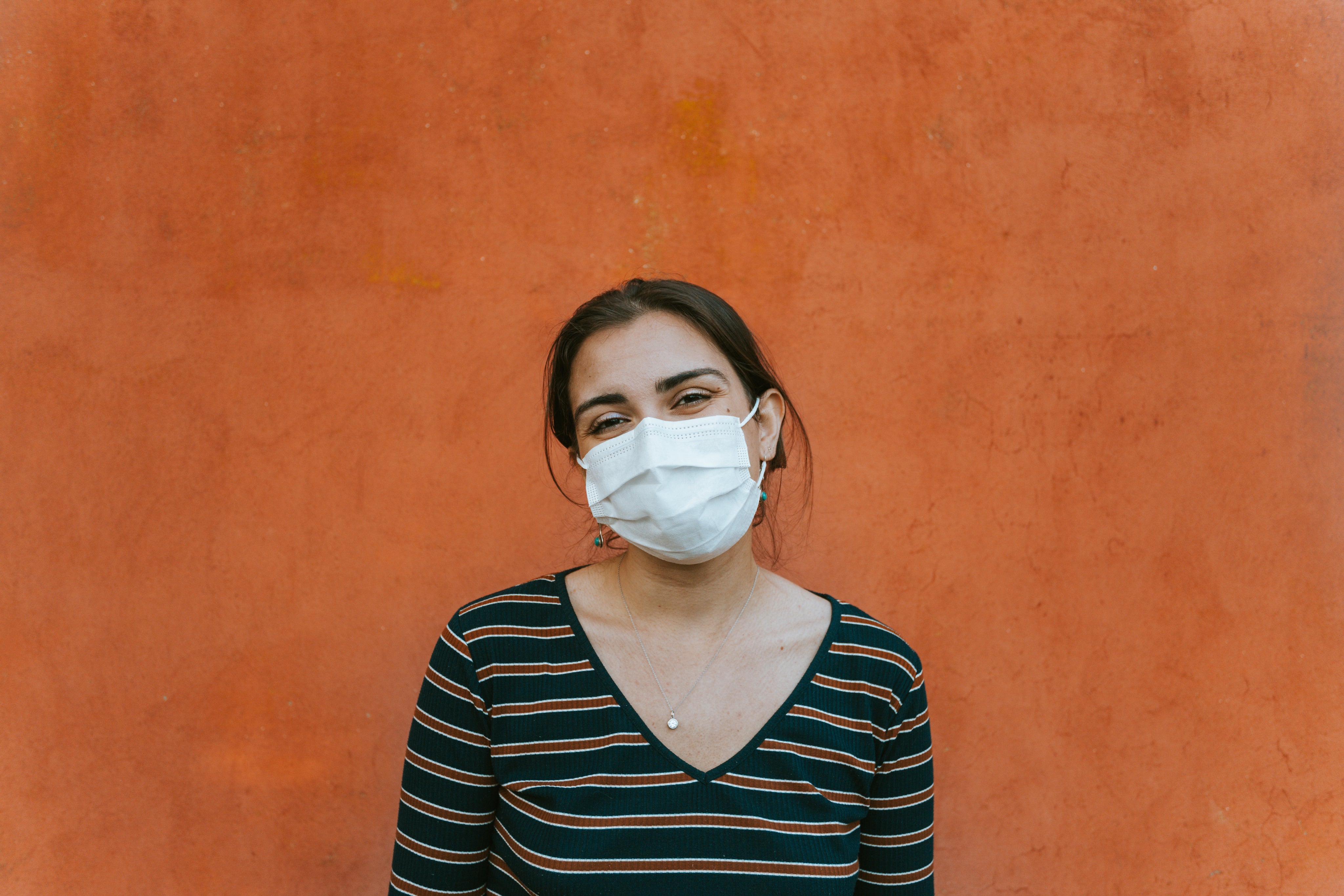 files/smiling-person-in-a-facemask-by-an-orange-wall.jpg